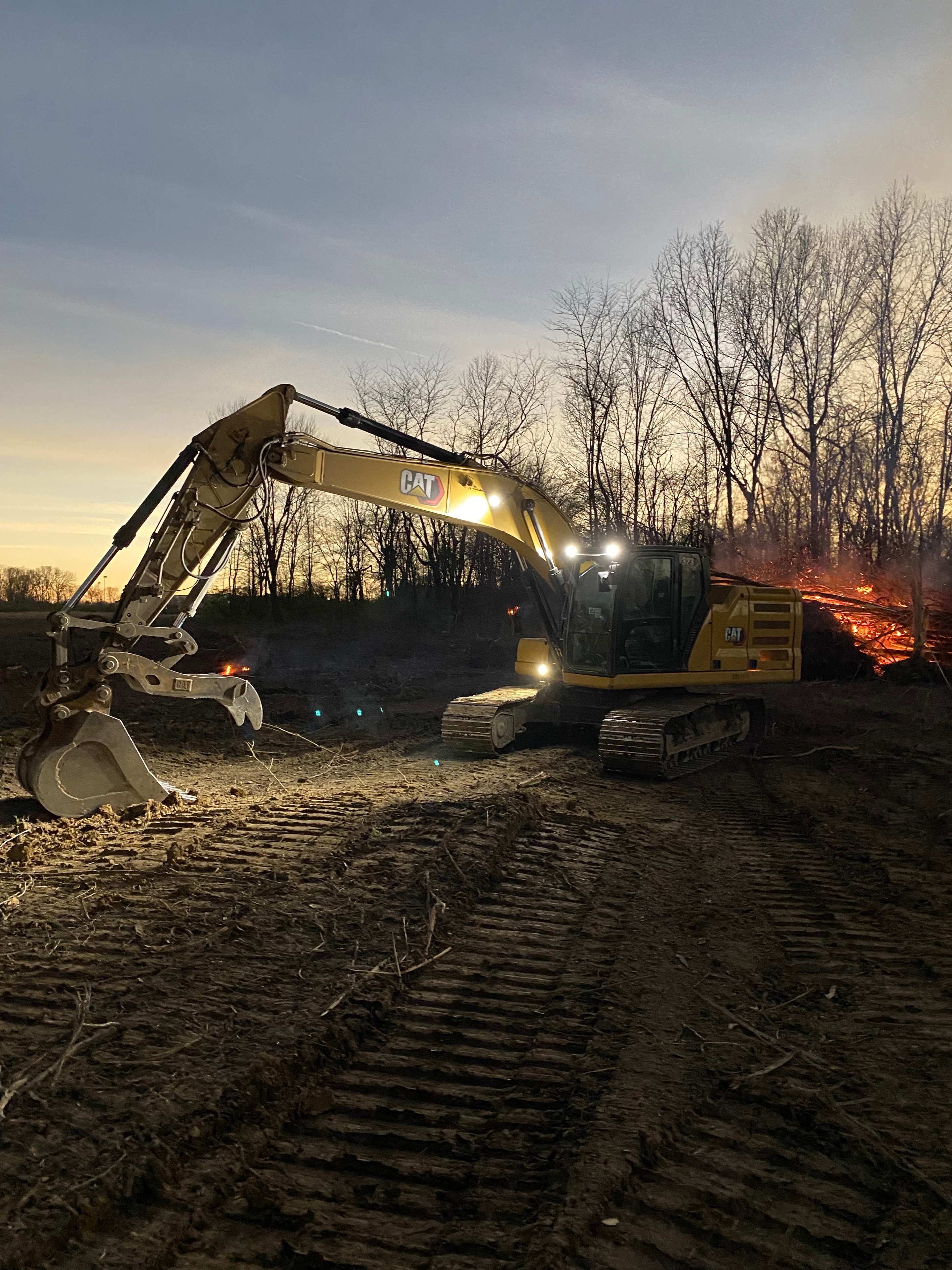 CAT excavator on job site at dusk